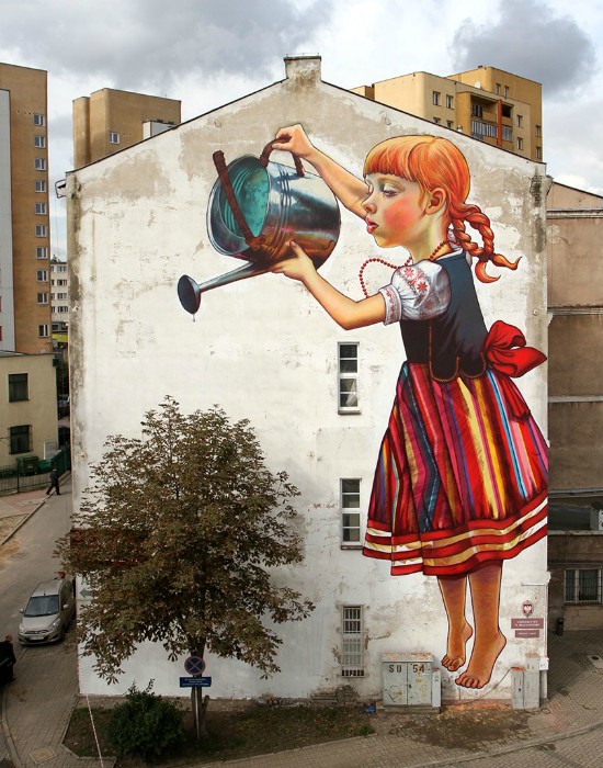 Девочка поливает дерево.