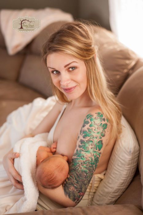 Татуированная мамочка кормит младенца.