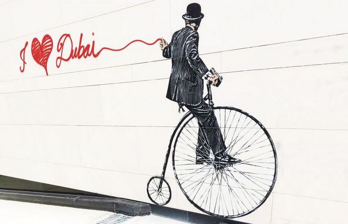 Граффити, рекламирующее передвижение на велосипеде в Дубае.