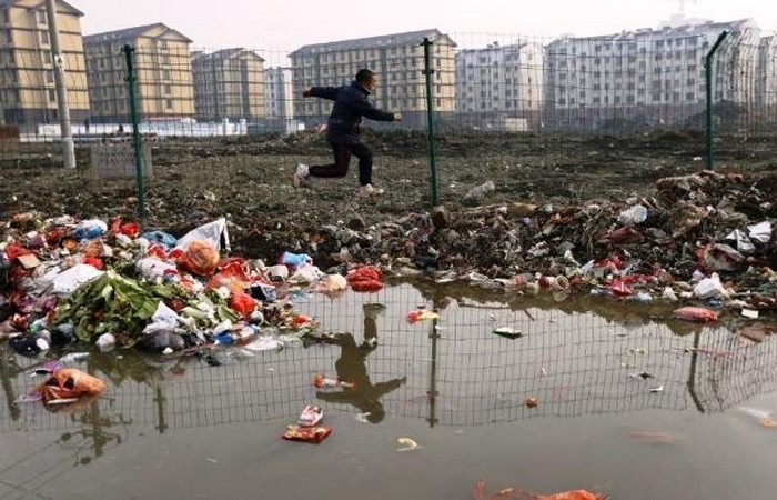 Мальчик прыгает через кучу мусора, Цзясин.