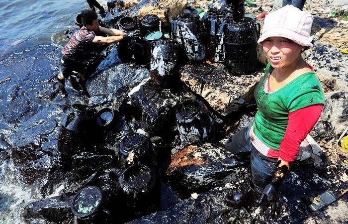 В очистительных работах при разливе нефти участвуют даже женщины, Далянь.