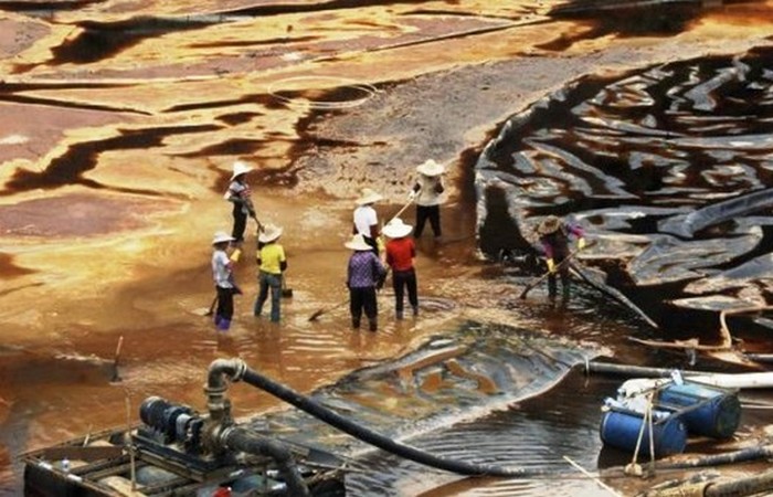Люди вычищают крупный разлив нефти в провинции Ляонин.