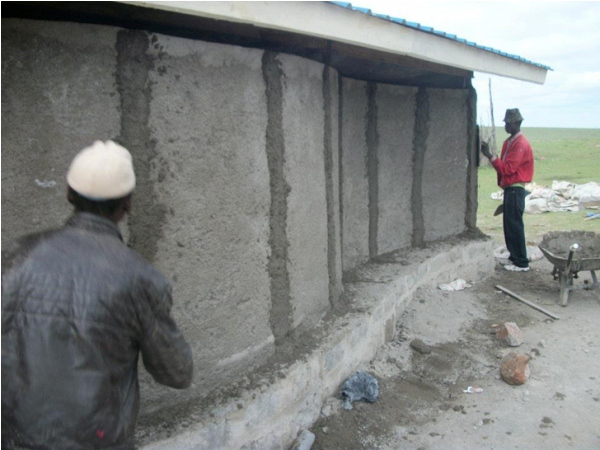 Мужчина масаи заняты подготовкой стен